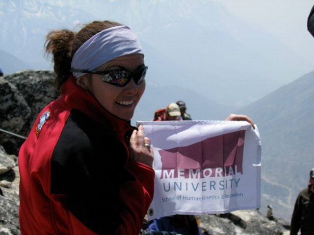 Jacinta holding the HKR flag atop Nagarsang Peak in Nepal